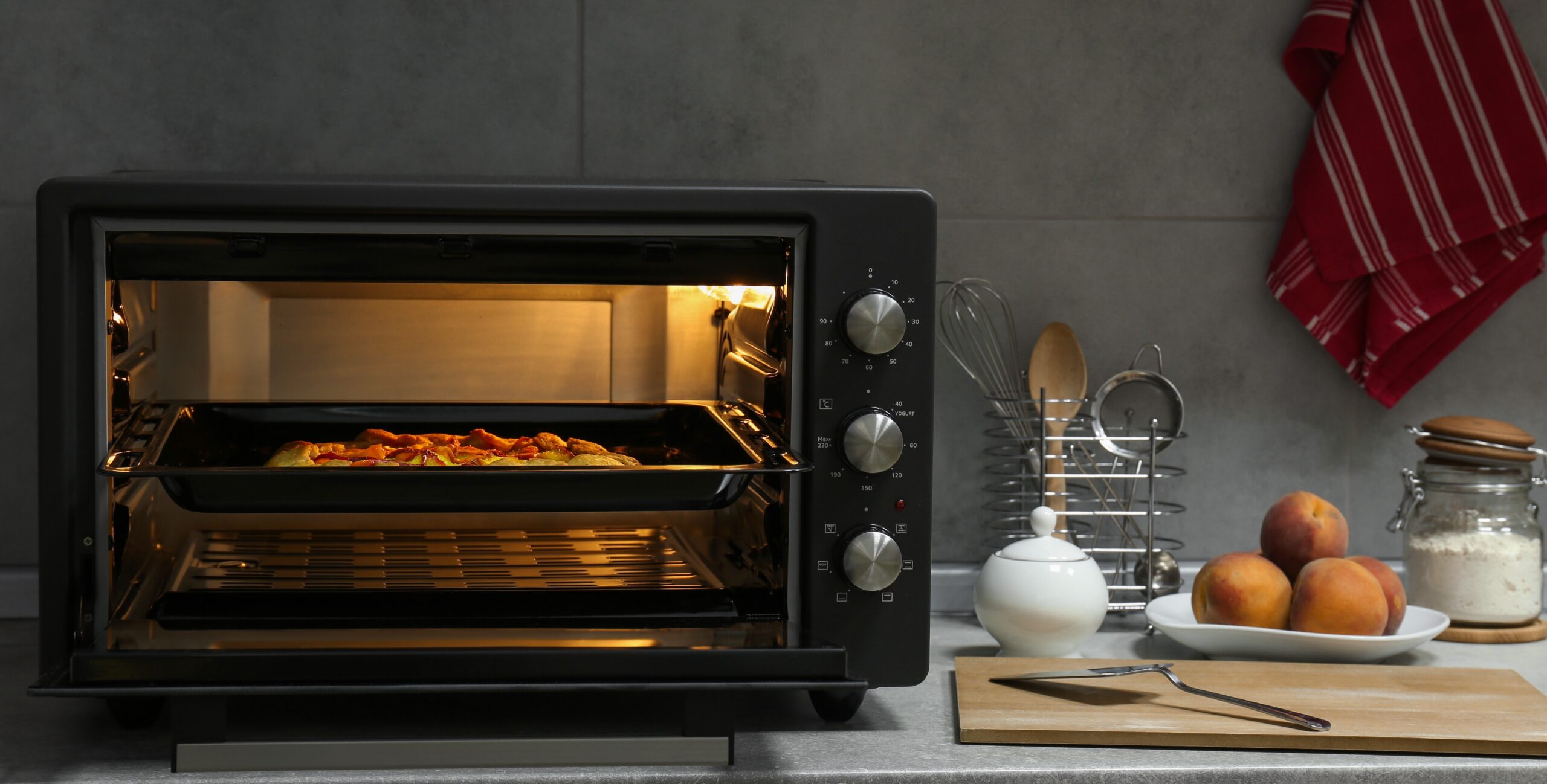 Mini four électrique ouvert avec tarte en cuisson sur plan de travail de cuisine