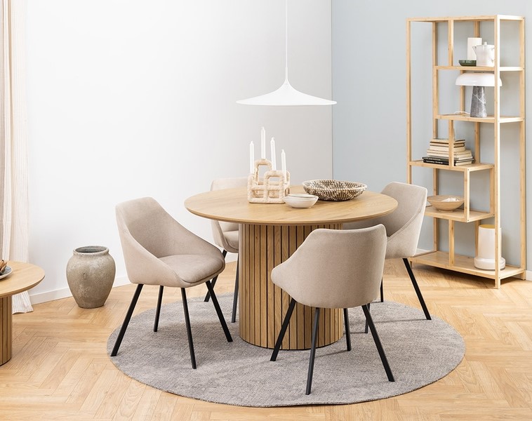 table à manger ronde avec chaises beiges dans un intérieur lumineux