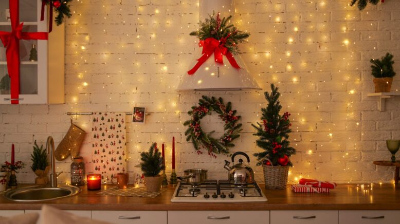 Cuisine décorée pour Noël avec un plan de travail en bois, une plaque de cuisson et des éléments festifs créant une ambiance chaleureuse et conviviale.