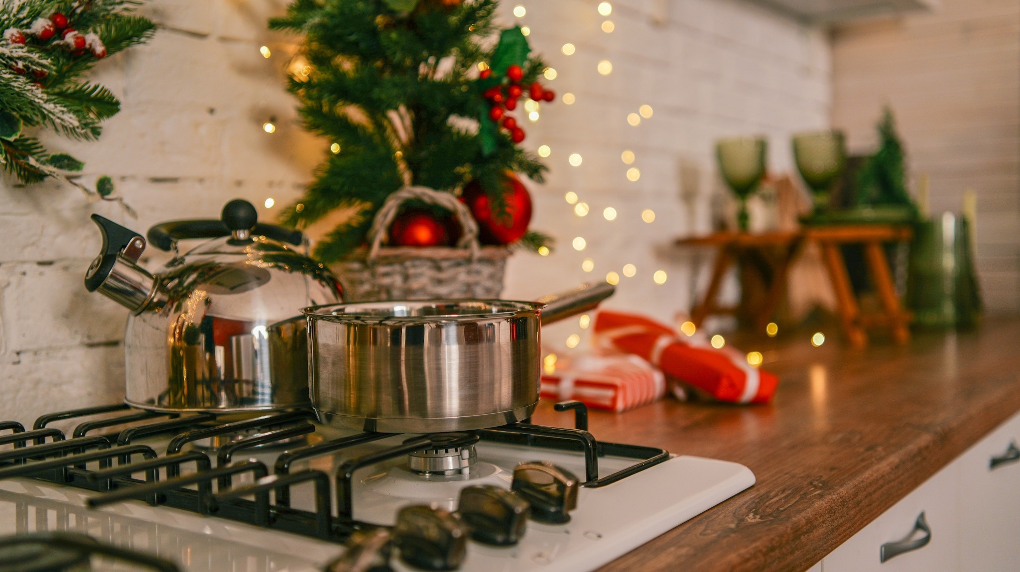 Cuisine décorée pour Noël avec un plan de travail en bois, une plaque de cuisson et des éléments festifs créant une ambiance chaleureuse et conviviale.