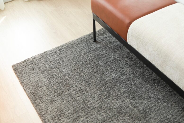 Pied fin de canapé en métal noir sur tapis gris