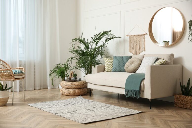 Salon lumineux à la décoration naturelle avec canapé beige, plantes vertes et mobilier en fibres naturelles
