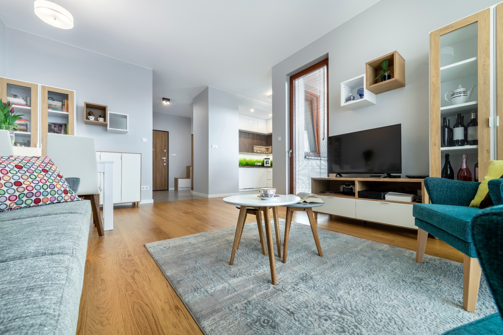 Aménagement et idée déco pour petit salon moderne avec meuble TV en bois et tapis gris.