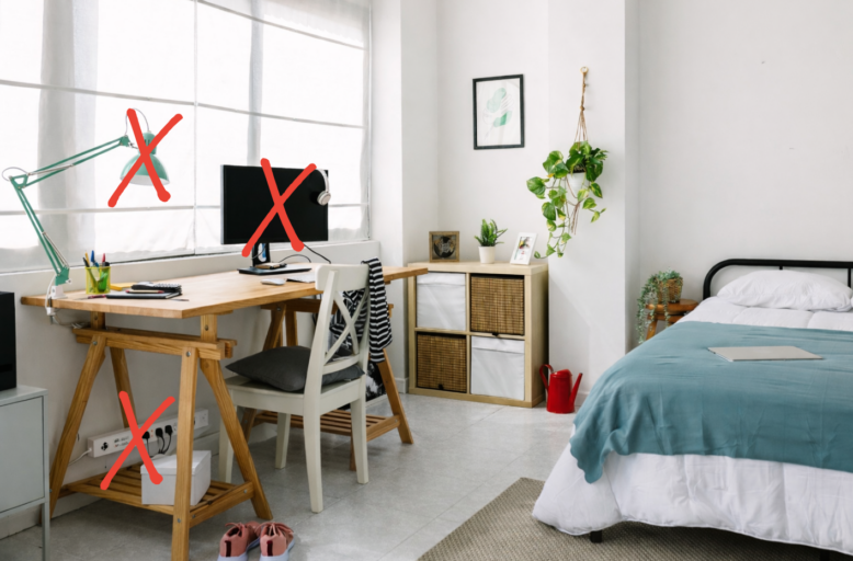 Vue d'une chambre-bureau où une lampe, un écran d'ordinateur et une multiprise sont barrés d'une croix rouge pour indiquer qu'ils sont des sources de chaleur à éteindre.