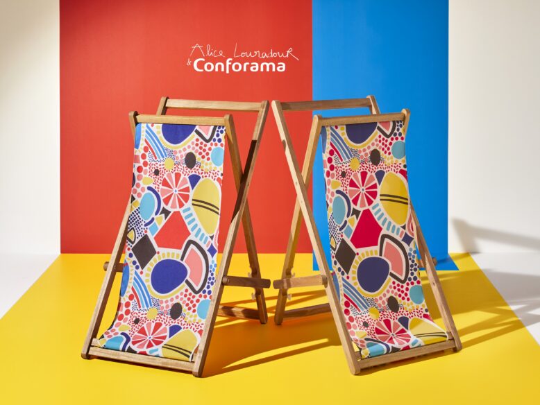 Deux transats Pernelle en bois avec une toile aux motifs colorés Alice Louradour sur fond bicolore bleu et rouge.